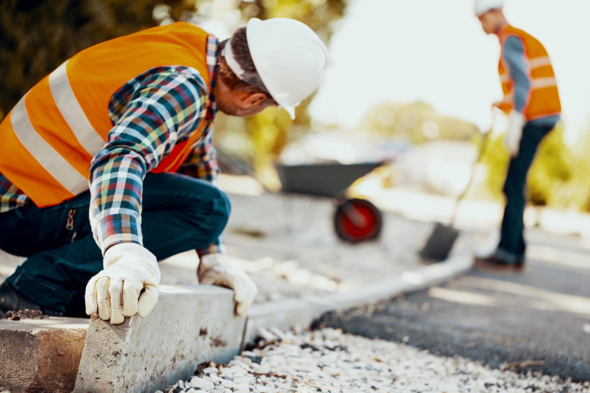 Two construction workers doing road work