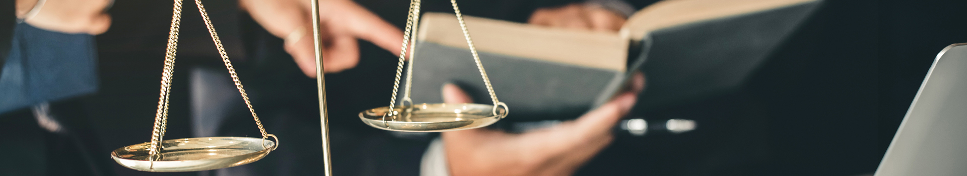 The Scales of Justice and a close up of two people's hands holding law books