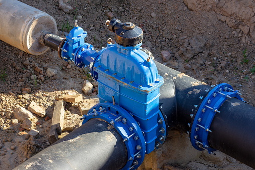 An underground water connection exposed and surrounded by dirt