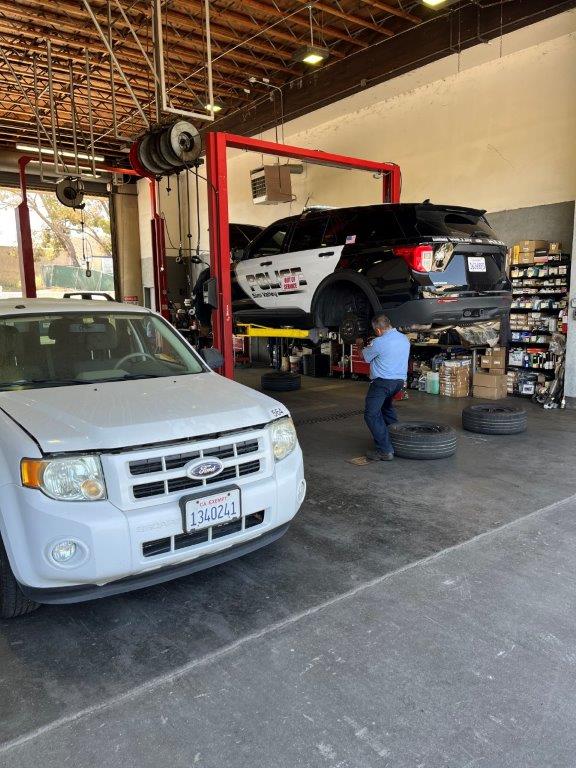 Maintenance worker repairing a police vehicle.