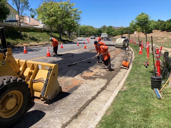 City Street Maintenance Employees Placing and Leveling Asphalt